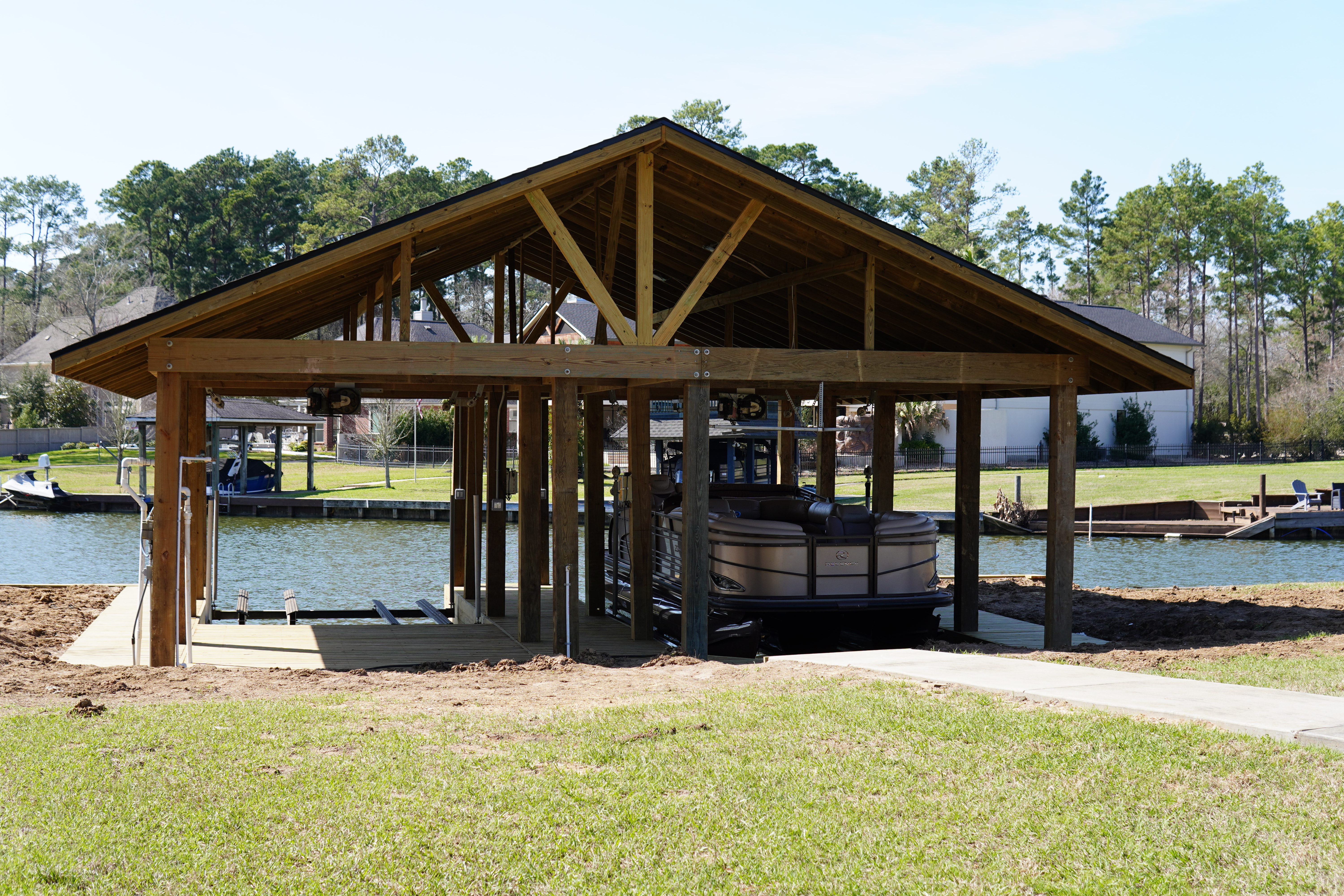 Completed wood boathouse with gabled roof and pontoon